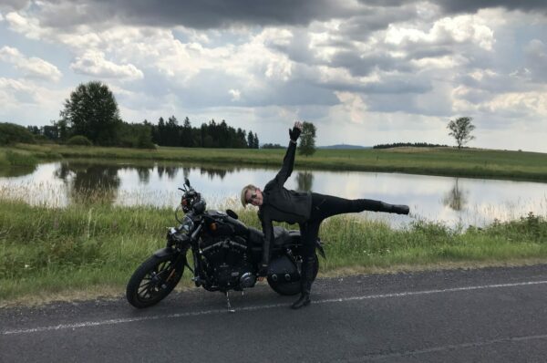 Motorrad und Yoga Asana vor einem See