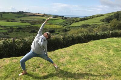 Yoga unterwegs: hier Reverse Warrior auf einer grünen Wiese in Irland
