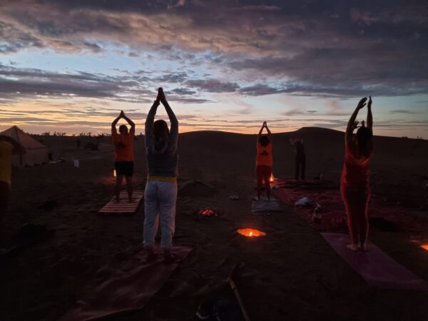 Yoga zum Sonnenuntergang inmitten der Sahara