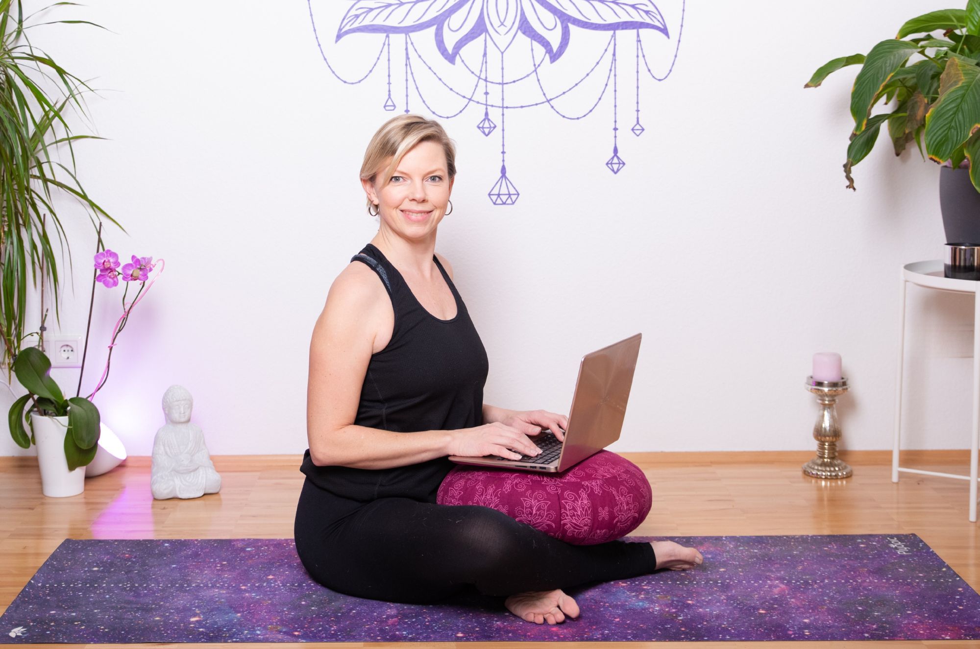 Person auf Yogamatte mit Laptop